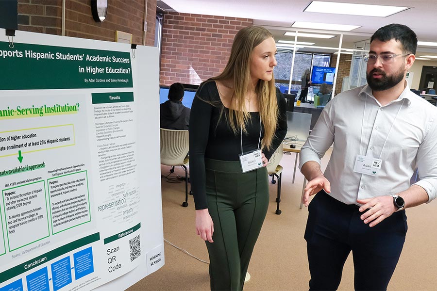 Bailey Himebaugh y Adan Cordova presentan «¿Qué obstaculiza el éxito académico de los estudiantes hispanos en la educación superior?» durante el Simposio de Excelencia Académica en la Biblioteca Cofrin.