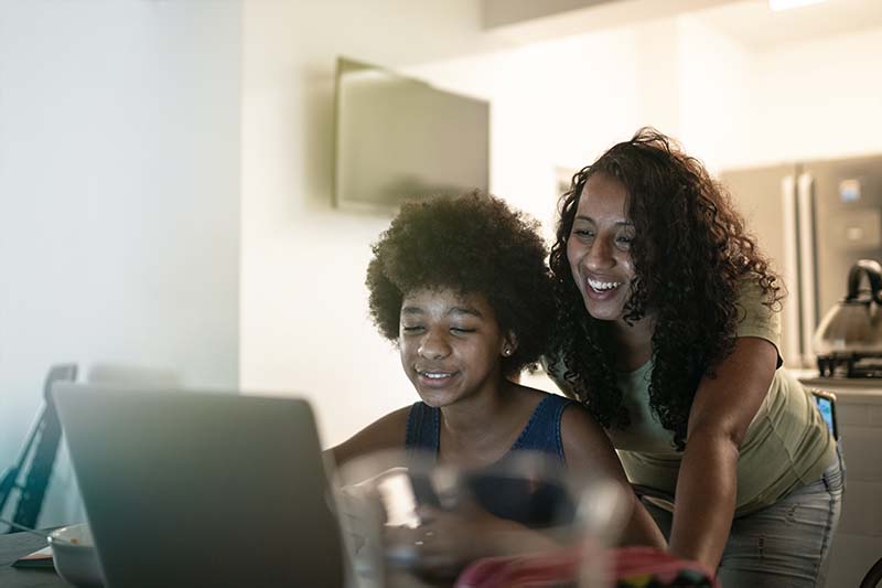 parent with teen looking at laptop