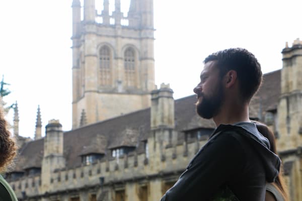 Male student poses in front of historical buildings while studying abroad