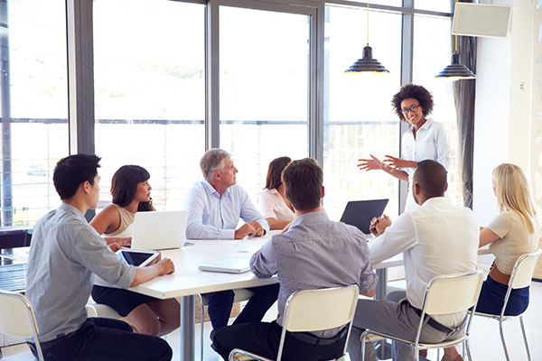 businesswoman presenting to a group in conference room with windows