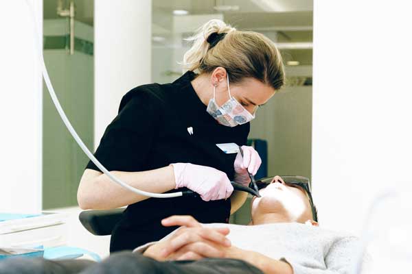 Dental Hygienist cleans patients teeth