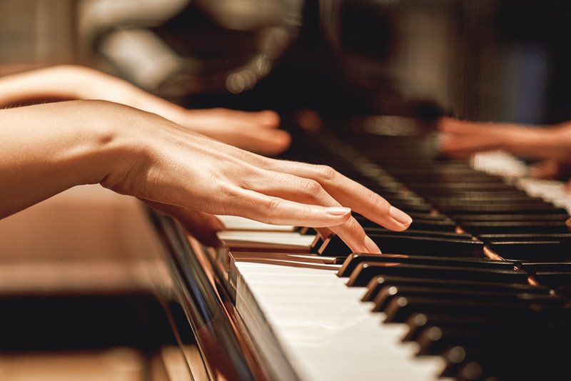 hands playing piano keys