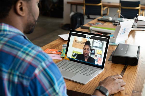 African American man on a virtual call with a African American woman on his laptop screen