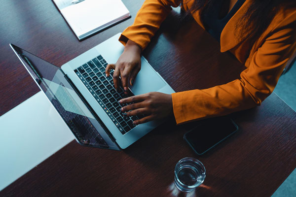 Hands typing on laptop