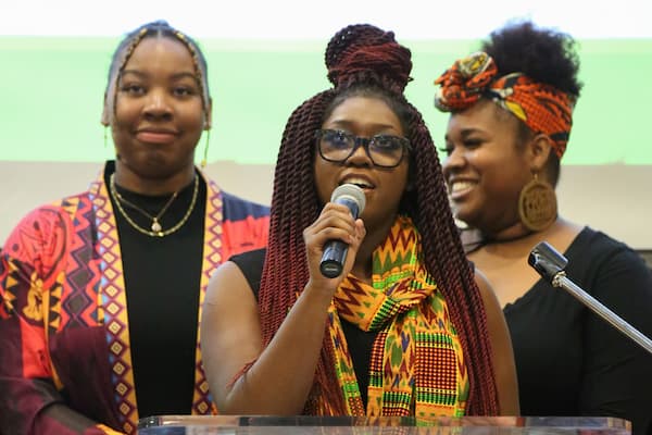 Three African American females give speed at event