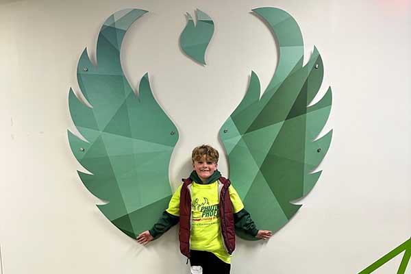 Student in front of Phoenix wall art