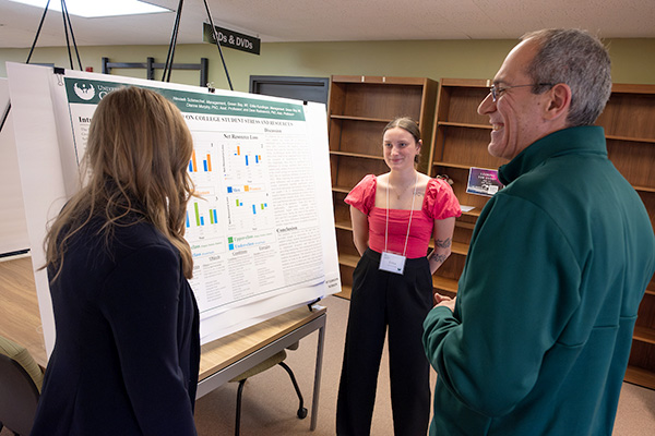 Students explaining their research to the Chancellor