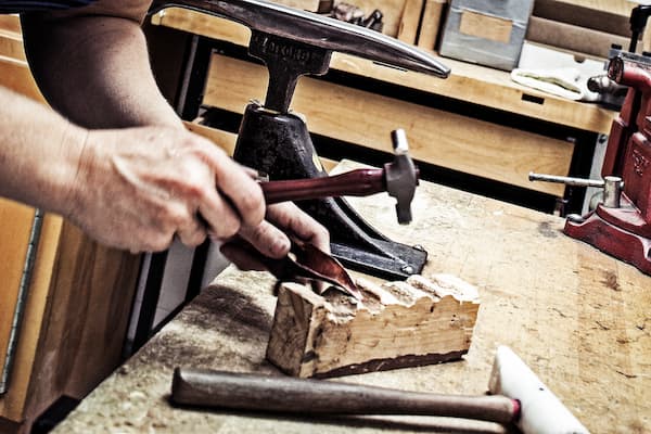 Barbi Gossen shapes her metal piece with embossing hammer