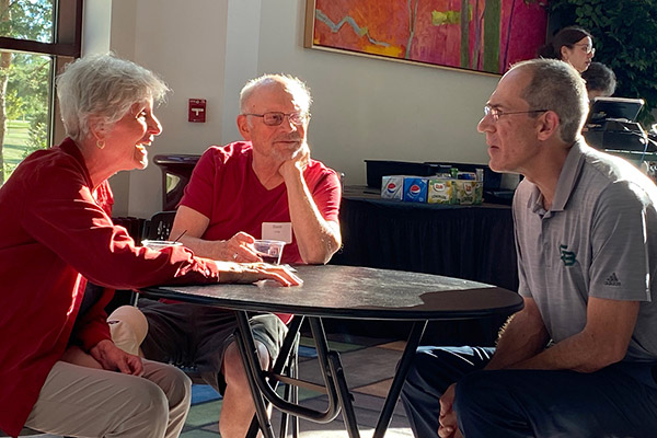 Chancellor speaking casually with retirees at a table