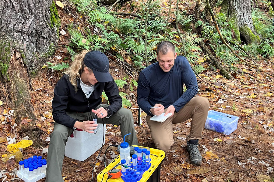 Two students gather water samples