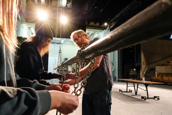 Students work backstage with professor