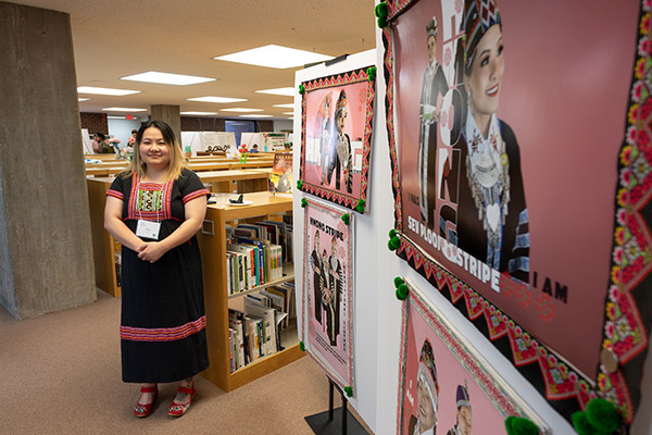 Student standing in front of their research display