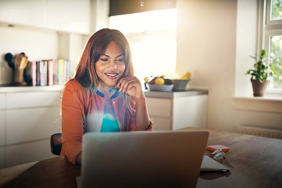 woman working on laptop in kitchen