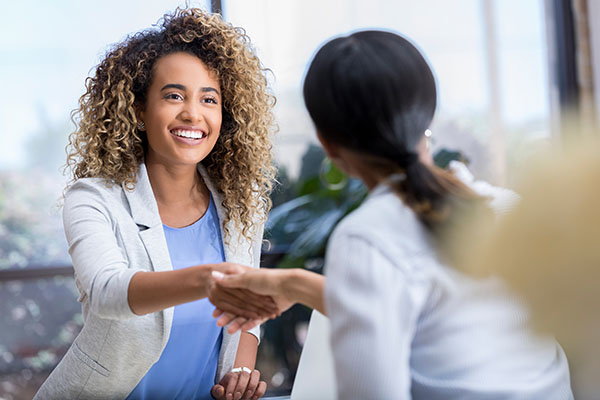 woman shaking hands with another woman