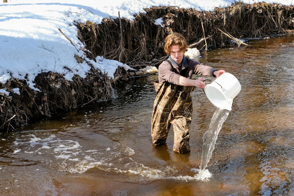 Student dumps bucket of water in river