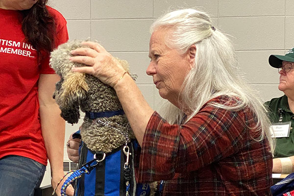 woman petting therapy dog