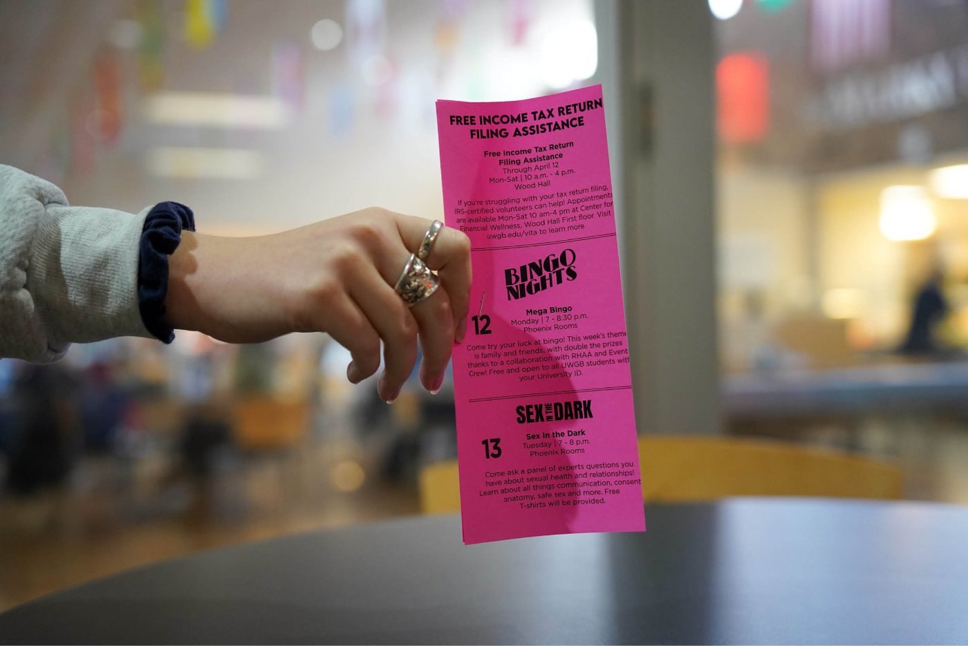 A bright pink table tent is placed on a table in the Social House (cafeteria)