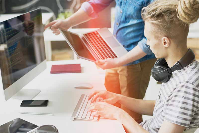 teacher working with student at computer