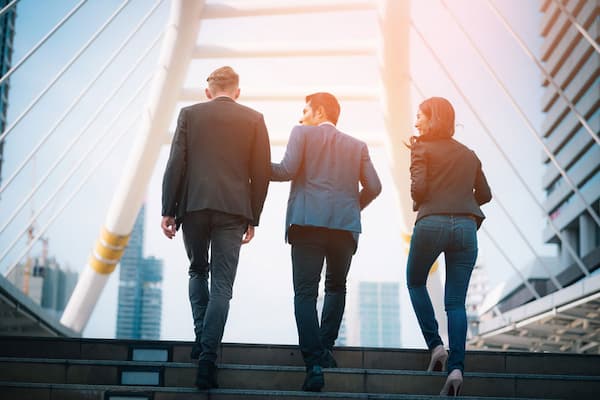 Three business people walking up stairs