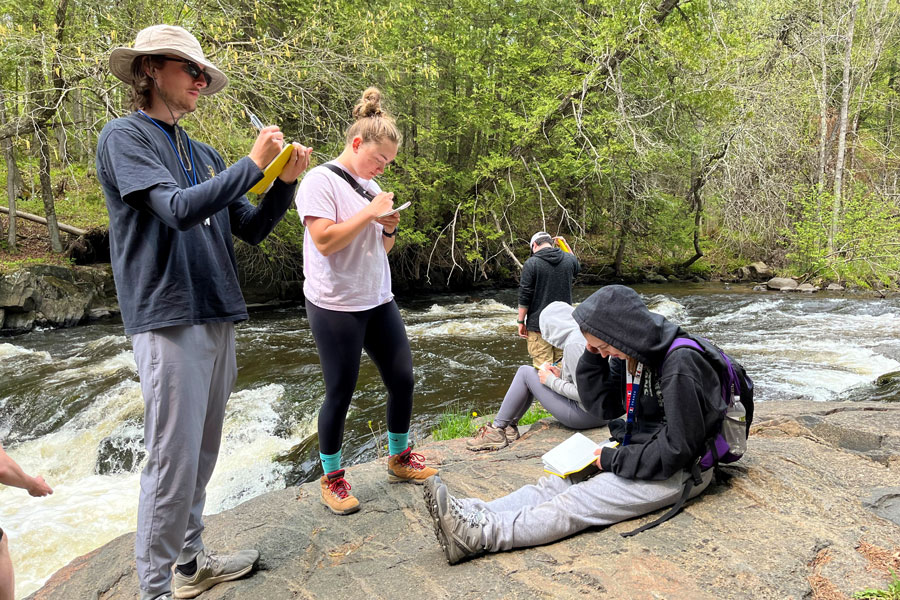 Group of student collecting river water data
