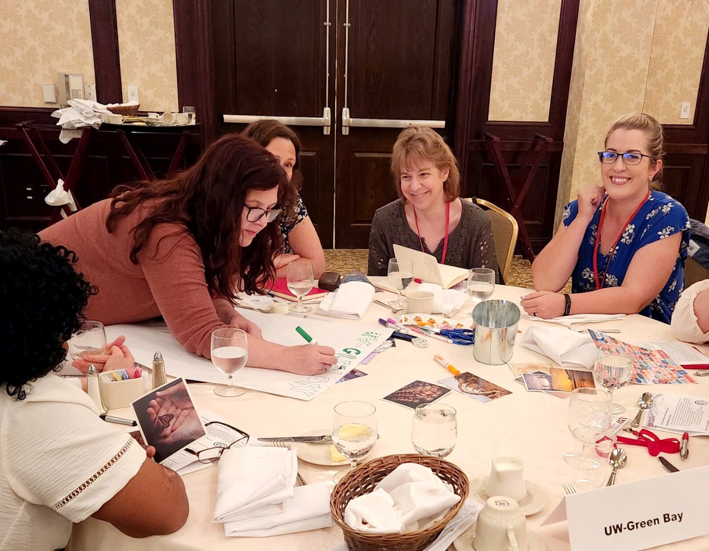 a group of instructors sitting around a table and working on a poster