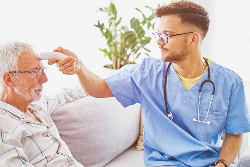 nurse taking senior man's temperature