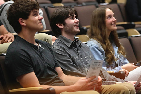 three students listening to presentation