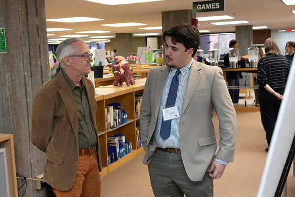 Two men discussing a research project in the library