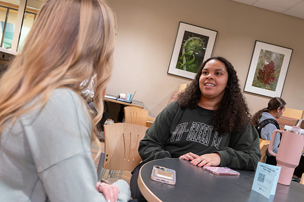 Two students talking at table in union