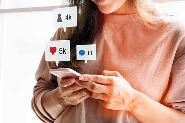 woman using a smartphone to view social media reactions