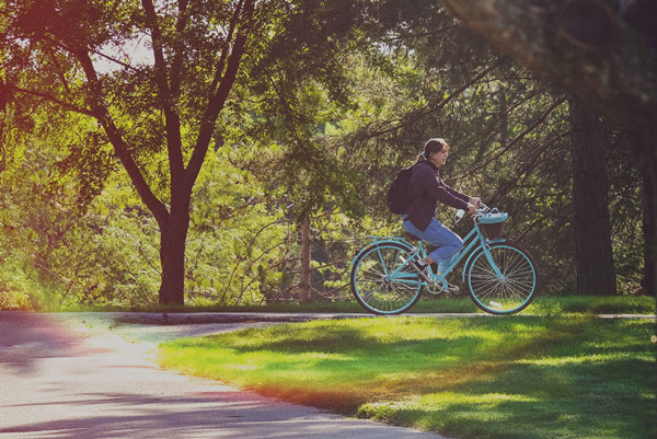 Student riding bike on campus