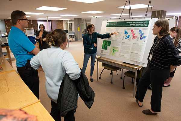 Group of people in front of large research poster