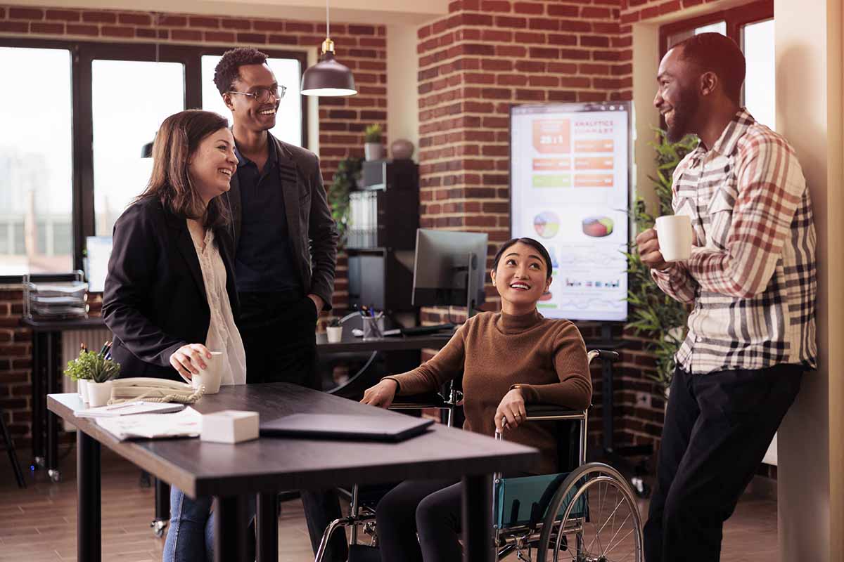 woman in wheelchair meeting with coworkers