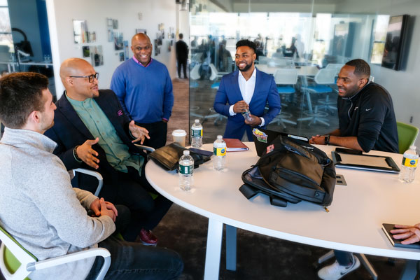 Group of males sitting around table and networking