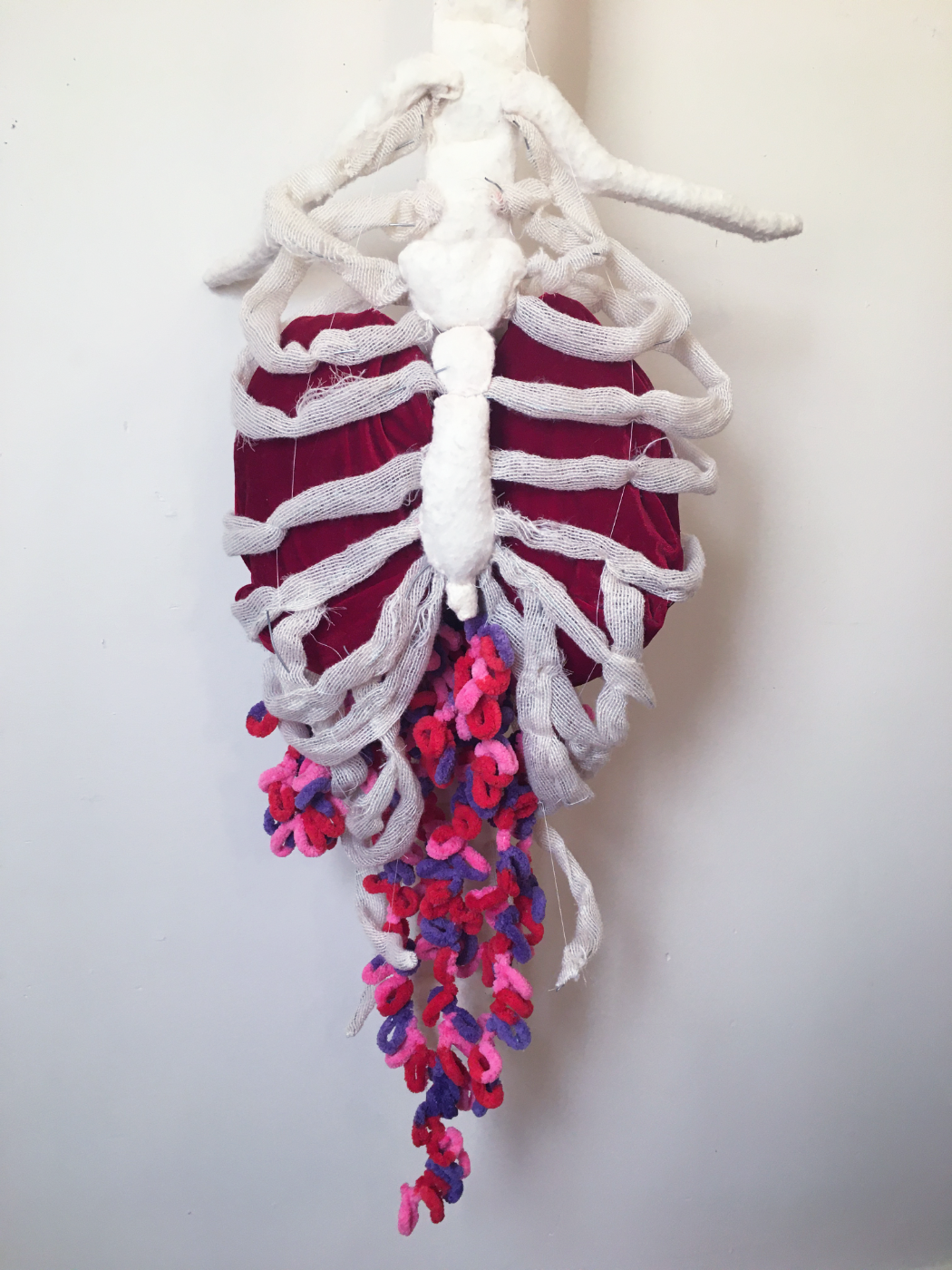 A textile art piece of a ribcage with entrails.