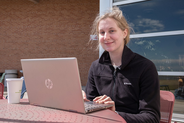 Student with laptop outdoors