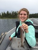 Person holding a fish in a boat