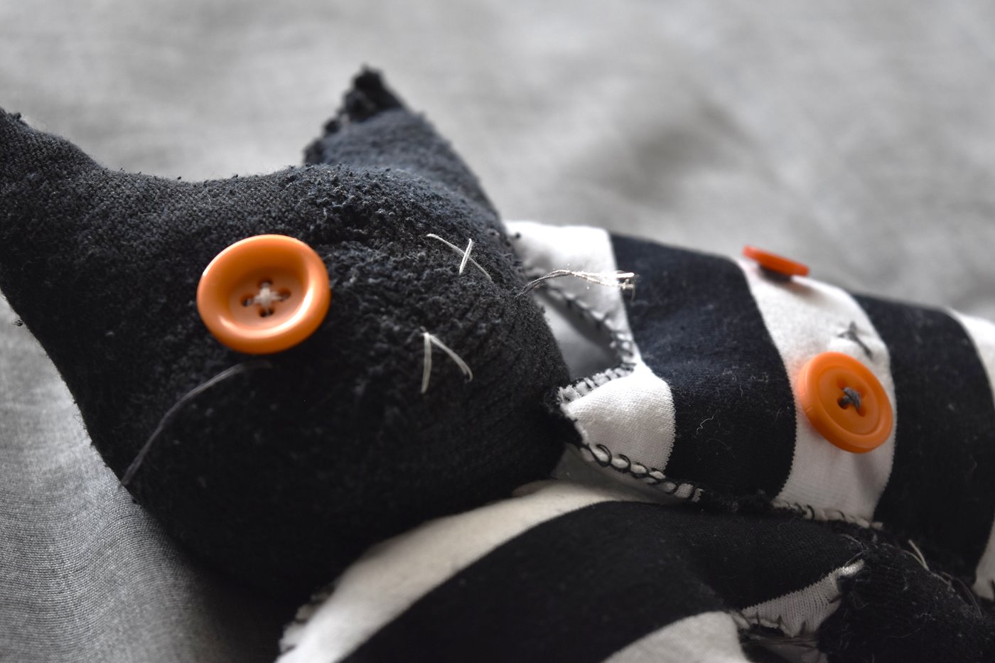 Photo of two handmade stuffed cats leaning on each other