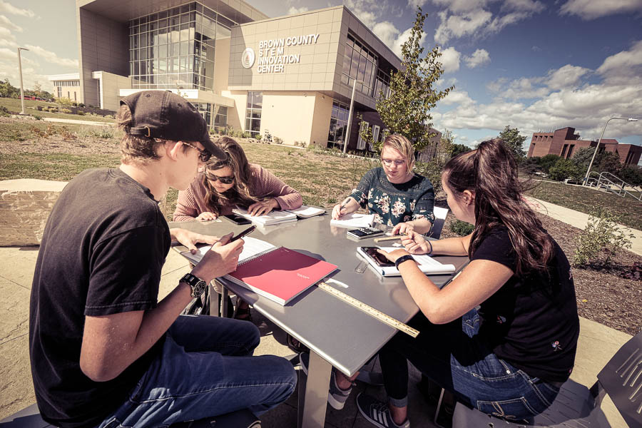 students working outdoors at a table at uwgb