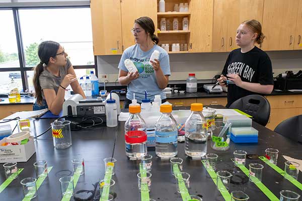 Professor helps students perform water testing.