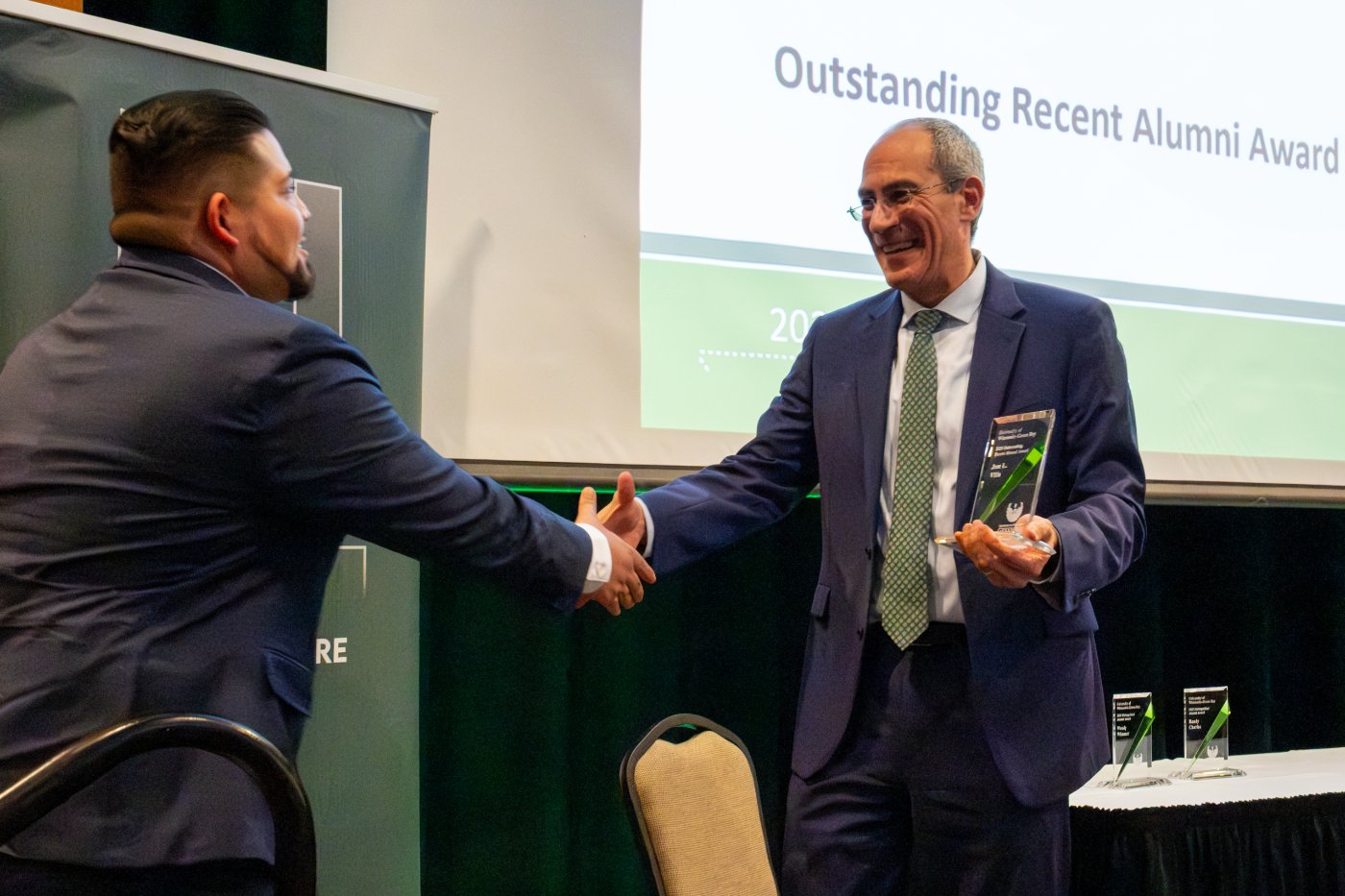 2025 Outstanding Recent Alumni Award recipient Jose Villa accepting award from Chancellor Mike Alexander