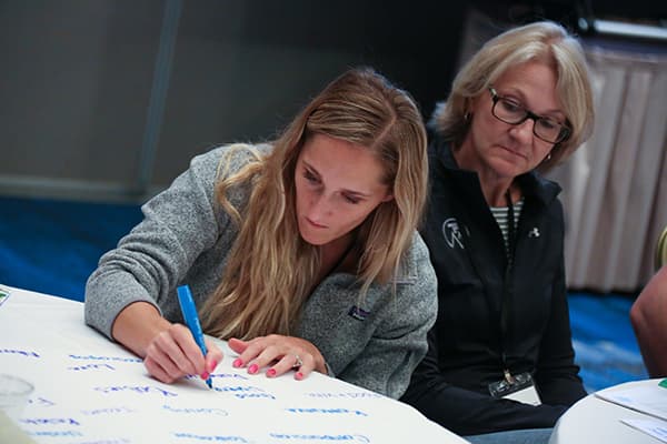 Groupwork activity, woman writing on a large sheet of paper