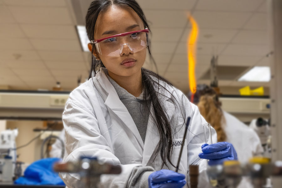 Student experimenting with flame in lab