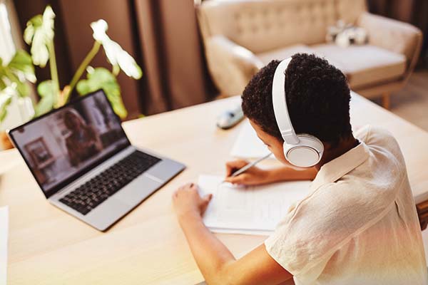 Student studying online with headphones and a laptop