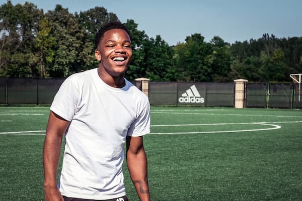 Male student smiles outside