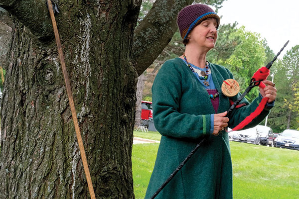 Kari Tauring performing a Viking tale next to a tree.