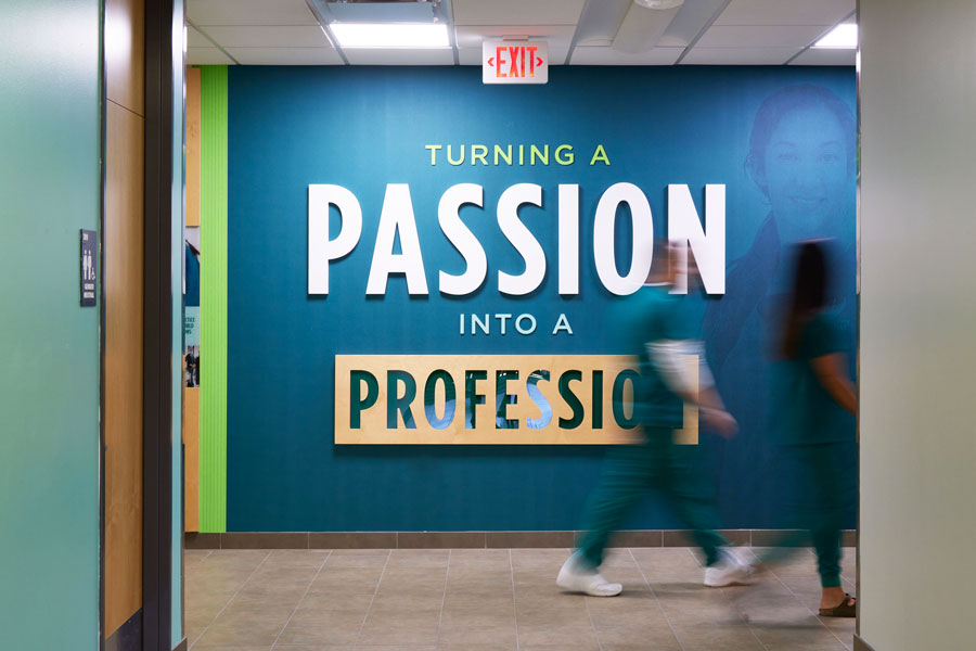 Students walking past wall with inspirational quote