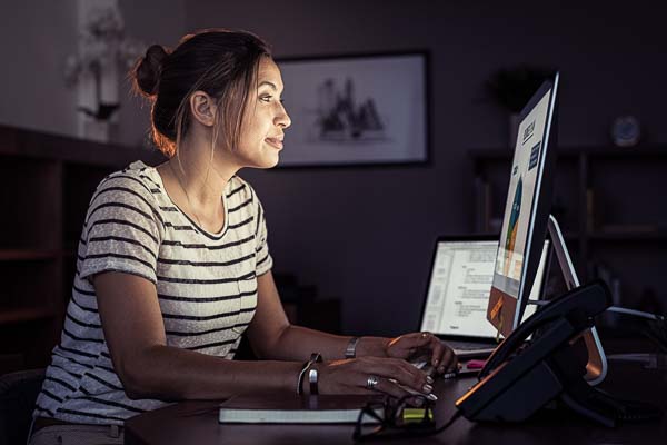 Sideways view of woman looking at computer screen