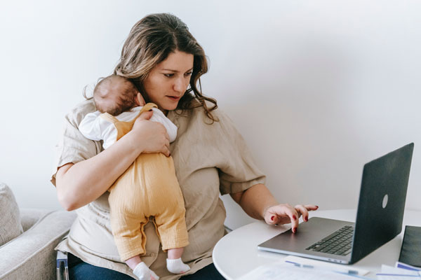 Online student working from home while holding child