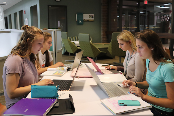 Students work on laptops in the Library Commons